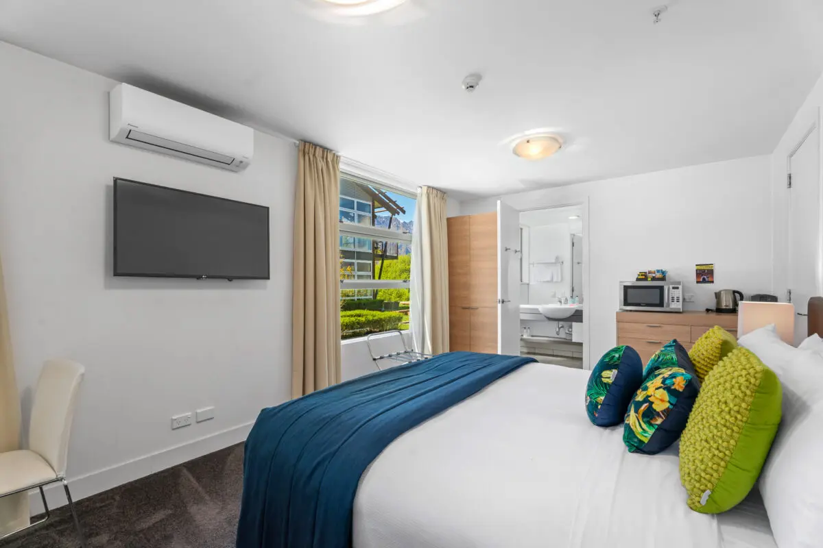 Waterfront Queenstown Studio king-size bed with modern linen and cosy décor