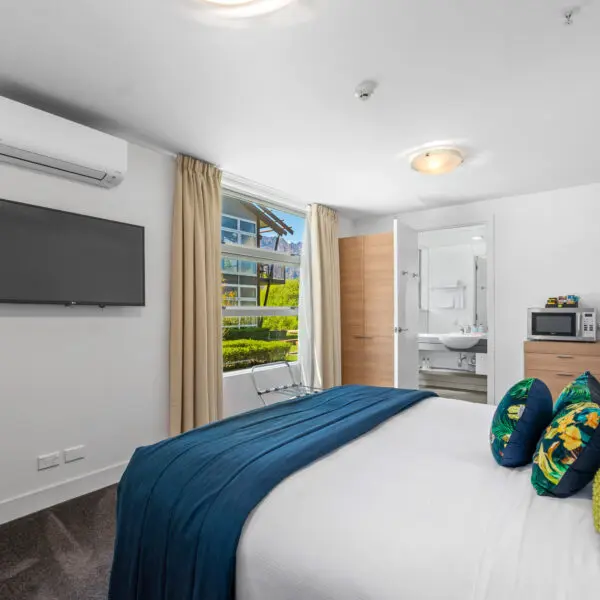 Waterfront Queenstown Studio king-size bed with modern linen and cosy décor